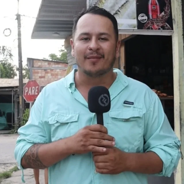 Retrato de Sergio Andres Rojas Montero con un micrófono en una calle